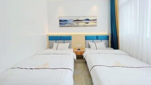 Una habitación de hotel con dos camas, un cuadro en la pared y una ventana con cortinas.