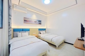 A hotel room with two beds, a desk, a TV, and a painting on the wall.