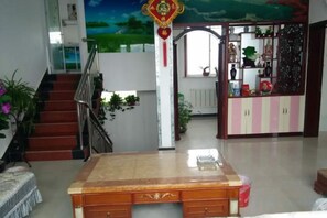 Una habitación con un amplio escritorio de madera, una escalera y vistas a un jardín.