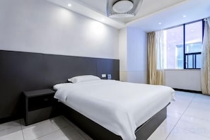 A modern hotel room with a large bed, a bedside table, and a window with curtains. - Tianyi Boutique Hotel (Jingzhou Lianghu Market) (Jingzhou)