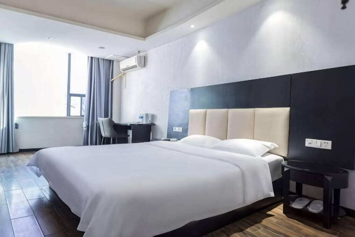 Une chambre d’hôtel moderne, dotée d’un grand lit, d’un bureau et d’une chaise.