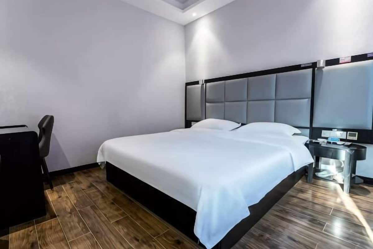 Une chambre d’hôtel moderne avec un grand lit, un bureau et une table de chevet.