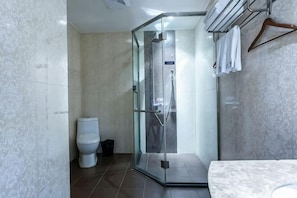 A bathroom with a glass-enclosed shower, a toilet, and a marble-tiled floor. - Tianyi Boutique Hotel (Jingzhou Lianghu Market) (Jingzhou)