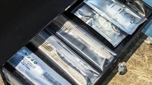 Een zwarte koffer met verschillende vakken en diverse spullen.