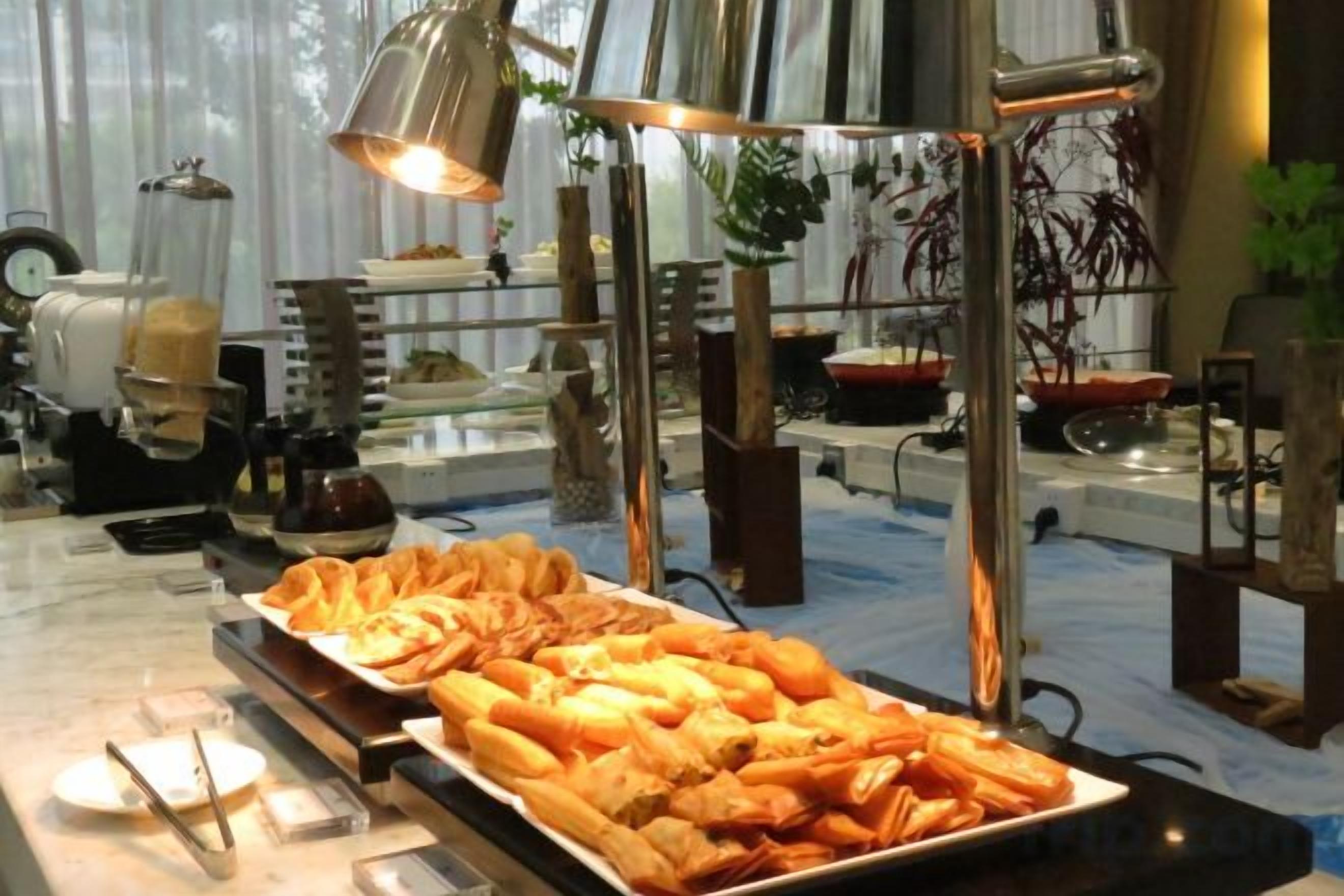 A buffet with various food items and a coffee machine.