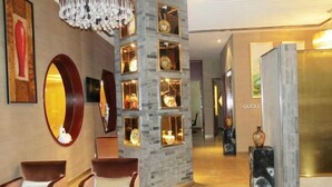 A lobby with a stone column, seating area, and a reception desk. - Anhui Construction New Era Hotel (Feidong)