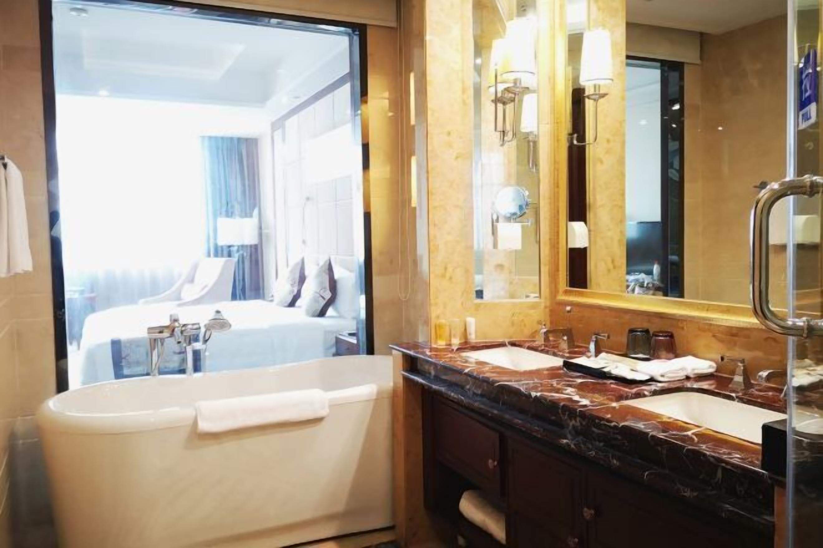 Un baño moderno con bañera, un espejo grande y un tocador doble.