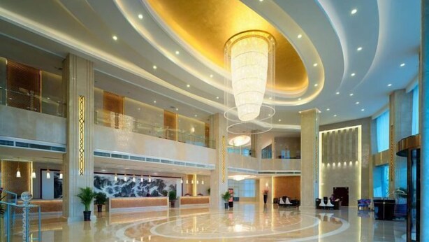 A spacious lobby with a large chandelier, multiple seating areas, and a reception desk. - Anhui Construction New Era Hotel (Feidong)