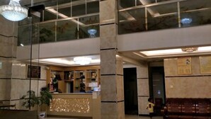 A hotel lobby with a reception desk, seating area, and large windows. - pingnanxianbaoshanbibgguan (Pingnan)