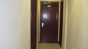 A narrow hallway with a wooden door at the end. - pingnanxianbaoshanbibgguan (Pingnan)