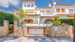 A large, two-story house with a white facade, multiple chimneys, and a gated entrance. - Beach front home in Platja d'Aro with WiFi (Platja d'Aro)