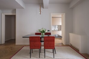 Un coin repas avec une table, des chaises et un vase de fleurs.
