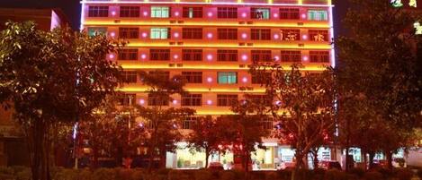 A multi-story hotel with illuminated signage and a well-lit facade.
