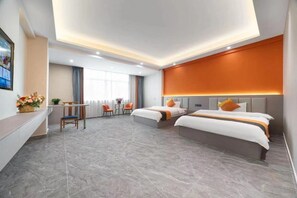 Una habitación de hotel moderna con dos camas, un escritorio y una zona de estar.