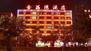 Een hotel met meerdere verdiepingen, verlichte signage en een rij ramen per etage.