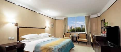 A hotel room with a bed, a desk, a chair, a television, and a window with a city view.