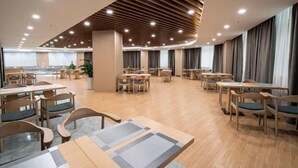 A spacious dining area with wooden tables and chairs, a modern ceiling design, and large windows with curtains. - Xinhua Hotel Nanchuan (Chongqing)