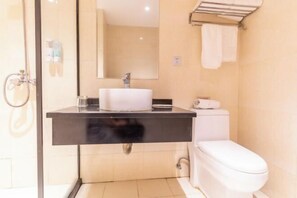 Un baño moderno con encimera negra, lavabo blanco y retrete.