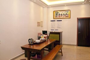 A dining area with a wooden table, benches, a kettle, and a menu board on the wall. - Wuyishan Star B&B (Wuyishan)