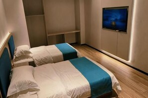 A room with two beds, a TV on the wall, and a wooden floor. - Tumed Zuoqi Zhejiang Jiadu Business Hotel (Tumed Left Banner)