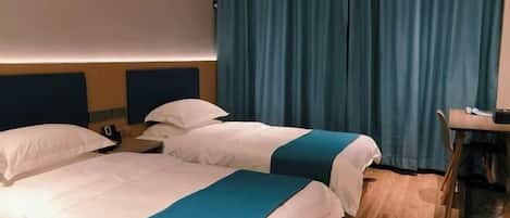 Habitación de hotel con dos camas, un escritorio y una silla.
