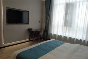 A hotel room with a bed, a desk, and a television on the wall. - Tumed Zuoqi Zhejiang Jiadu Business Hotel (Tumed Left Banner)