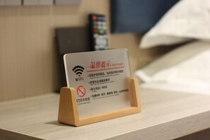 A wooden stand with a sign indicating WIFI availability and a no-smoking symbol. - Tumed Zuoqi Zhejiang Jiadu Business Hotel (Tumed Left Banner)