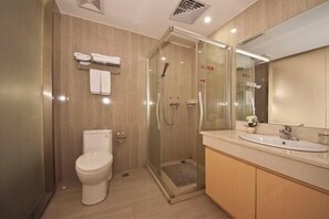 A modern bathroom with a glass-enclosed shower, a toilet, and a vanity with a sink. - Fuqing New Port Express Hotel (Fuqing)