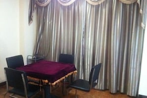 A dining area with a table covered by a purple cloth, surrounded by four chairs. - Fuqing New Port Express Hotel (Fuqing)