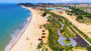 A coastal resort with a beach, a winding road, and a mix of natural and residential areas. - Amoy Bay Tourist Restort (Zhangzhou)