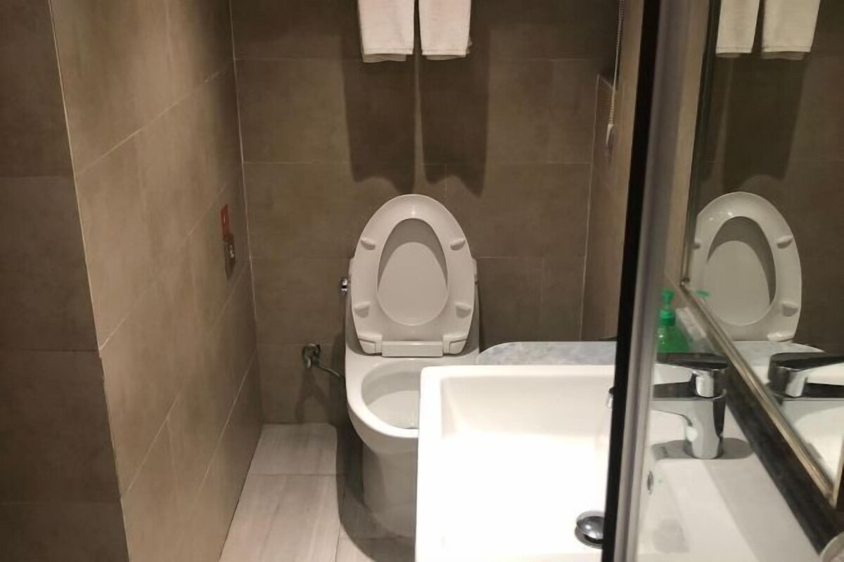 Et badeværelse med toilet, håndvask og spejl.