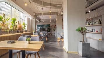 A modern interior with a bar area, seating, and potted plants.