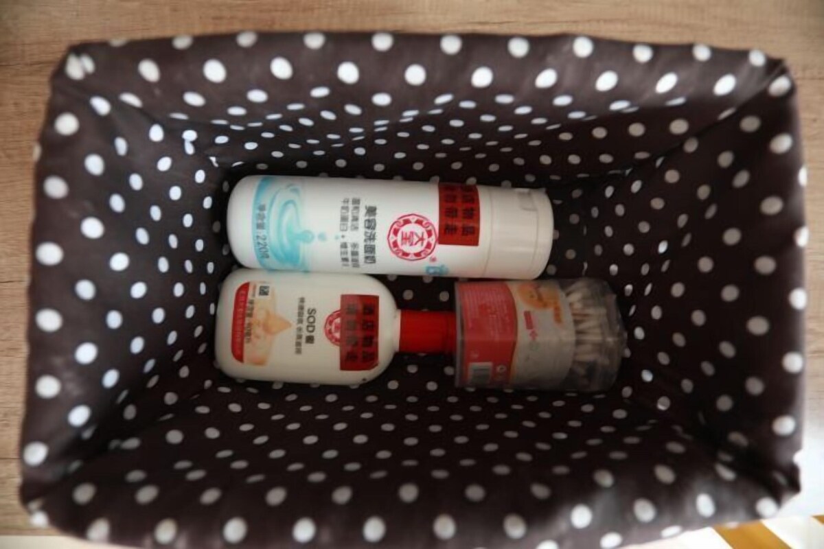 A polka-dotted bag containing three bottles, likely toiletries.