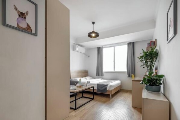 A modern hotel room with a bed, bedside table, and a potted plant. - Product family selection Hotel (Zhengzhou)