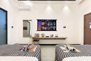 A hotel room with two beds, a desk, a large TV screen, and a mirror. - Bailuyuan Boutique Homestay (Fenghuang County)