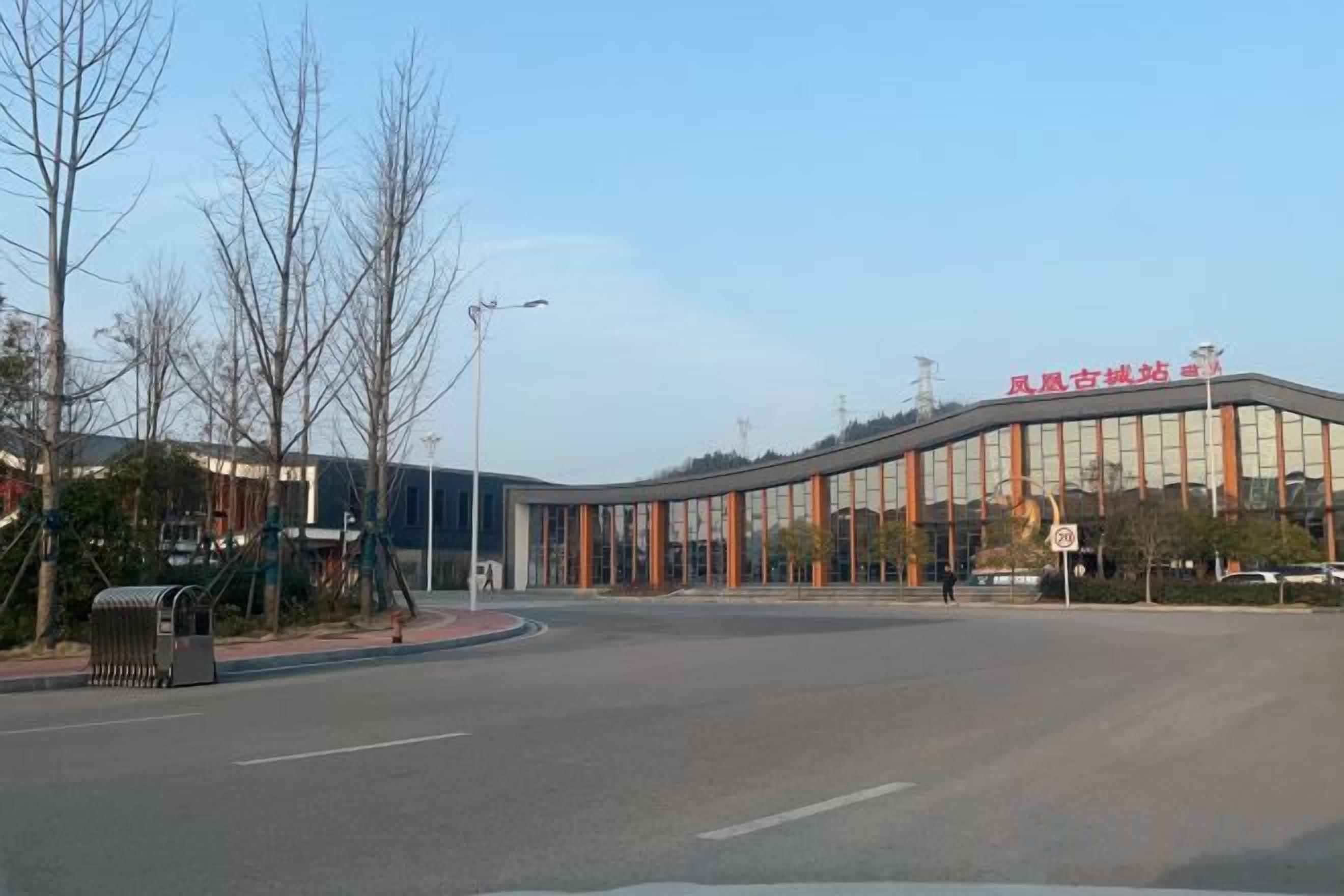 A modern building with a curved facade, large windows, and a clear sky.