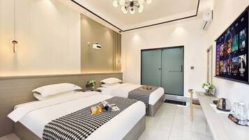A modern hotel room with two beds, a desk, a shower, and a wall-mounted TV.