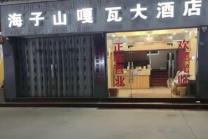 A hotel entrance with a dark facade and glass doors. - HaiziMountainGrandHotel (Daocheng County)