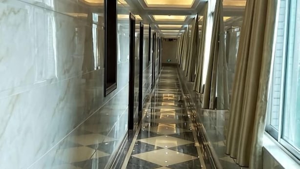 A corridor with reflective flooring, glass doors, and large windows. - Jinhui Hotel (Yangjiang)