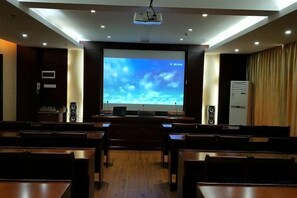 A conference room with a large screen, wooden tables, and a projector. - Jinhui Hotel (Yangjiang)