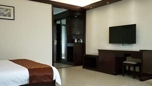 A hotel room with a bed, a desk, a chair, a television, and a wardrobe. - Jinhui Hotel (Yangjiang)