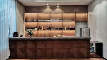 Zona de bar con mostrador, estanterías llenas de botellas y un refrigerador.