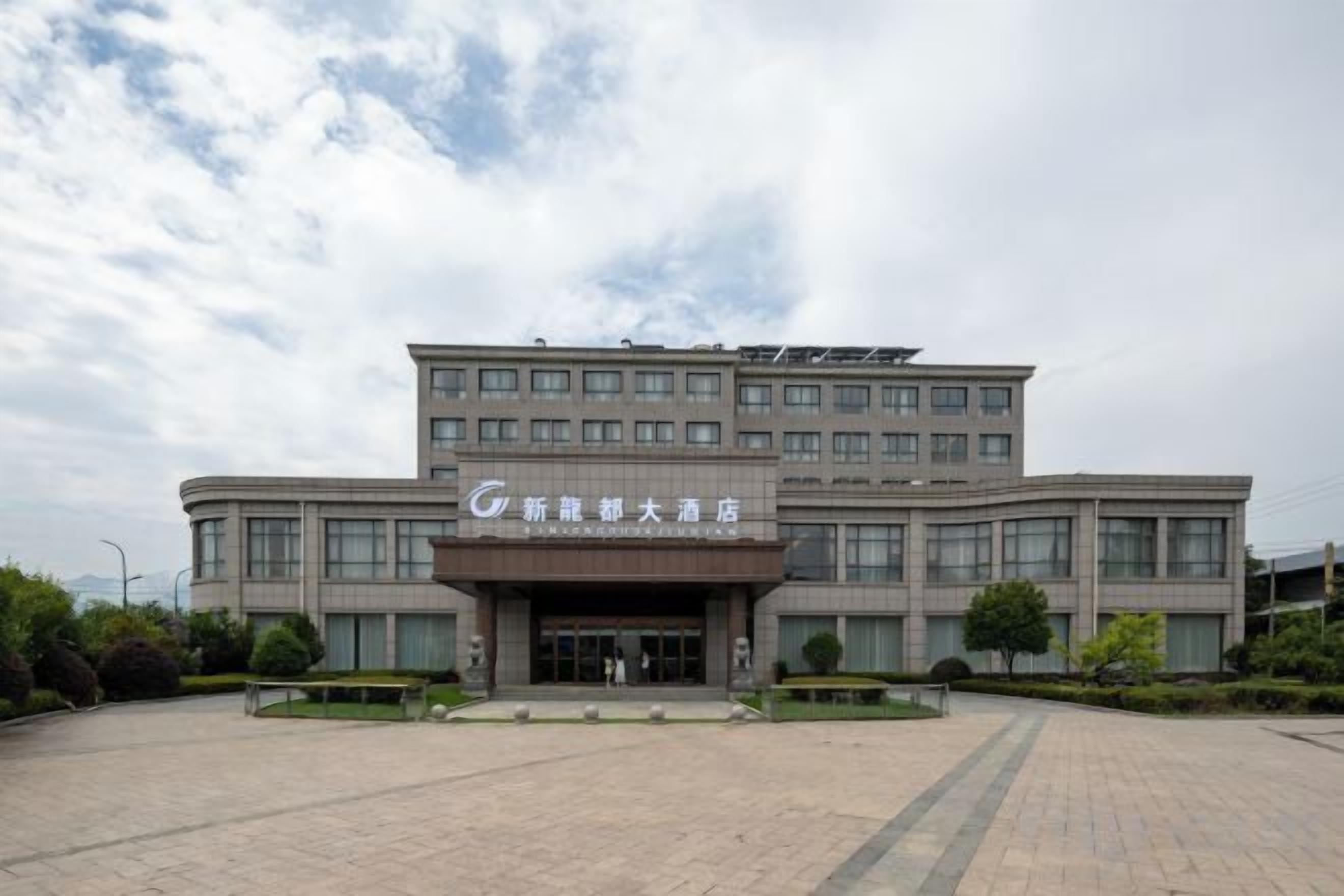 A multi-story hotel with a prominent entrance and a large parking area.