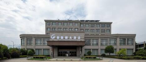 A multi-story hotel with a prominent entrance and a large parking area.
