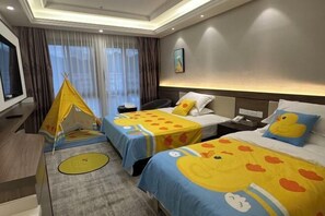 Ein Hotelzimmer mit zwei Betten, einem Zelt, einem Schreibtisch und einem Fernseher.