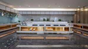 A modern reception area with a marble counter, glass partitions, and ambient lighting. - Long Du Hotel (Hangzhou)