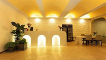 A reception area with a reception desk, seating, and a decorative wall.