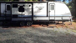 A recreational vehicle (RV) with a "Sovereign" logo, a sliding door, and a small window. - In the Beautiful redwoodss, 2acres .20 minutes from Crescent city (Crescent City,)