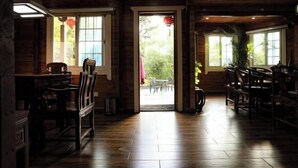 Un interior de madera con comedor, ventanas grandes y vistas al exterior.