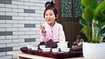 A table with a traditional tea set and a potted plant.